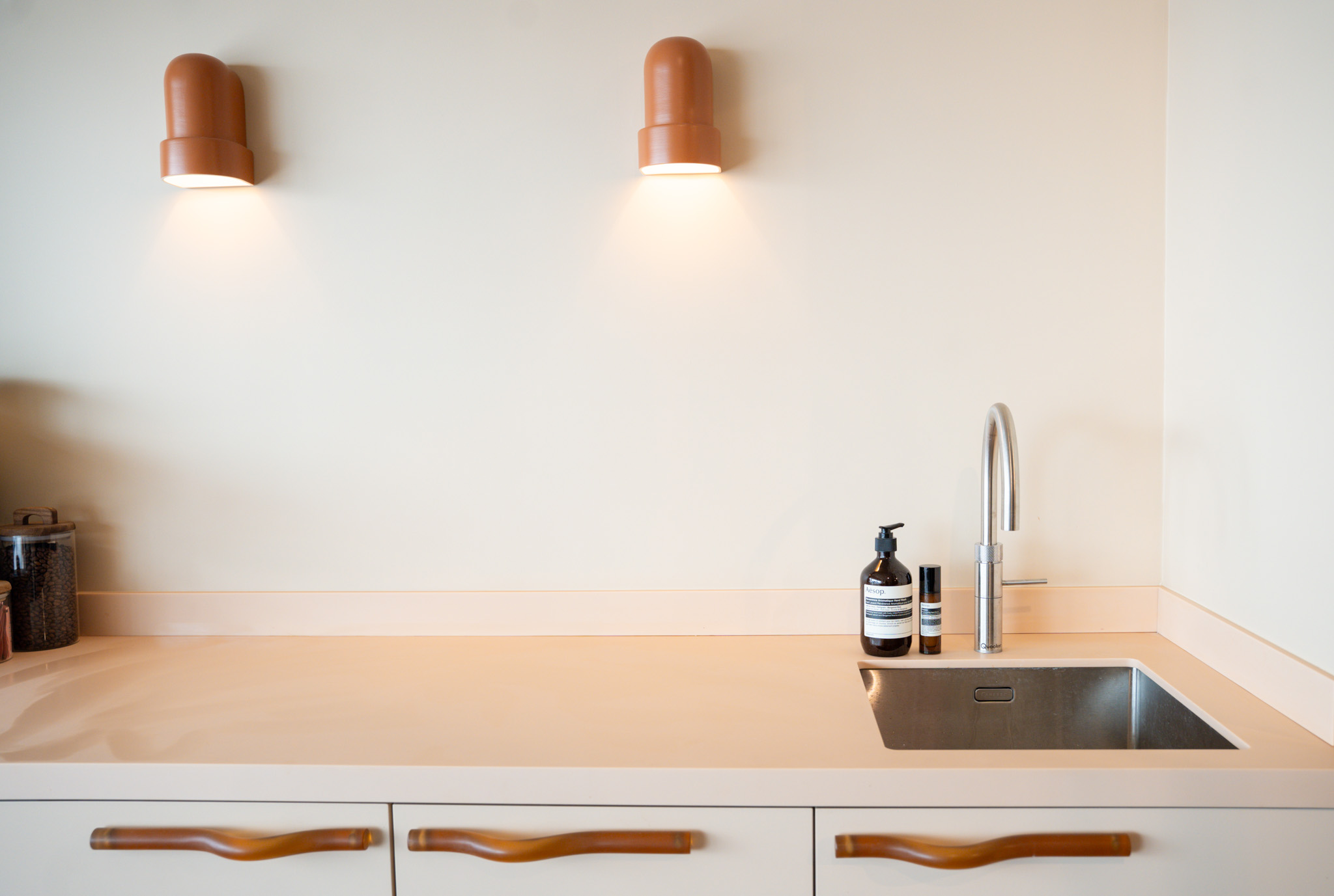 freddies studio bussum breed beeld twee wandlampen boven wastafel met aesop flessen