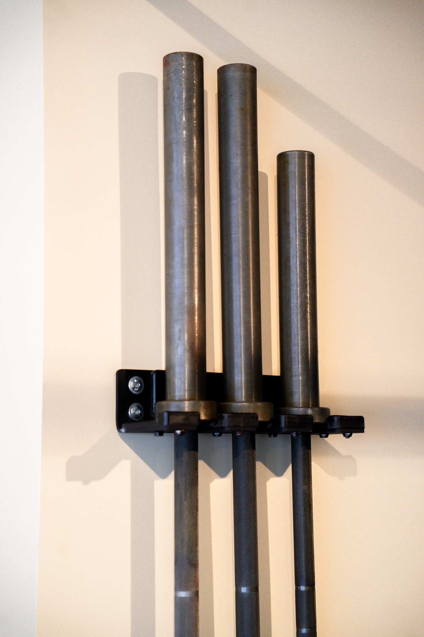freddies-studio-bussum-close-up-drie-barbellstangen-op-wandhouder