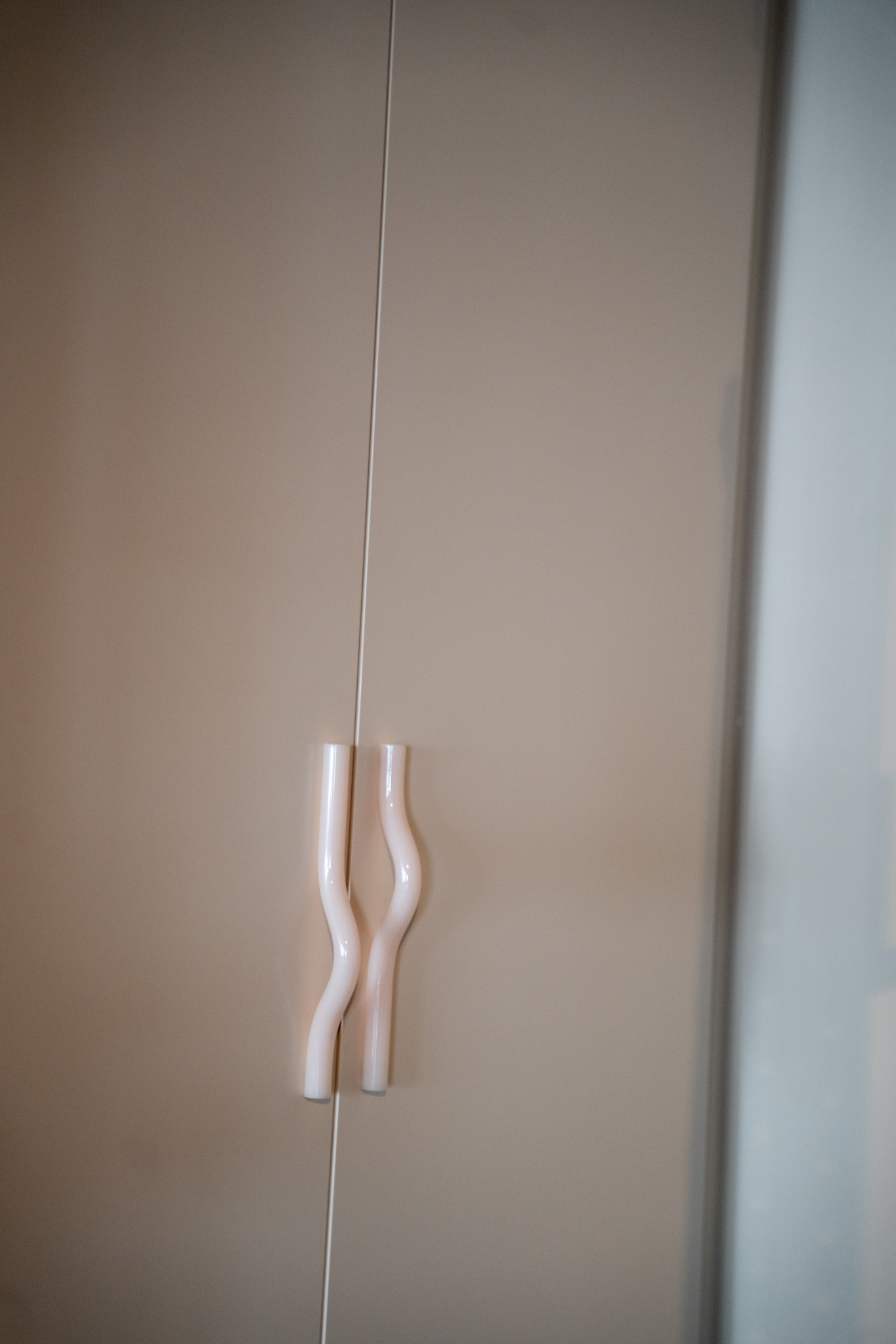 freddies-studio-bussum-close-up-golvende-witte-deurgreep-bij-fitnessruimte