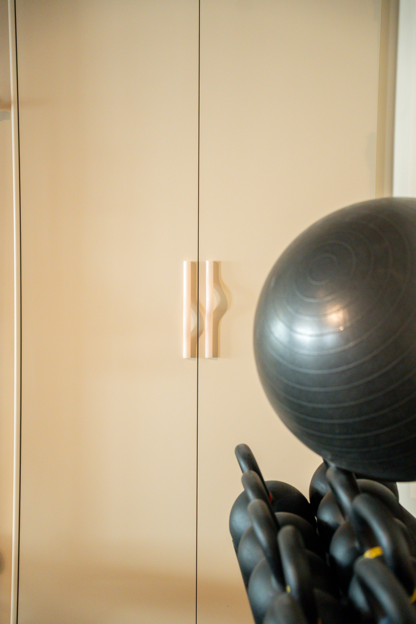 freddies-studio-bussum-close-up-golvende-witte-kastgrepen-naast-fitnessbal-en-kettlebells