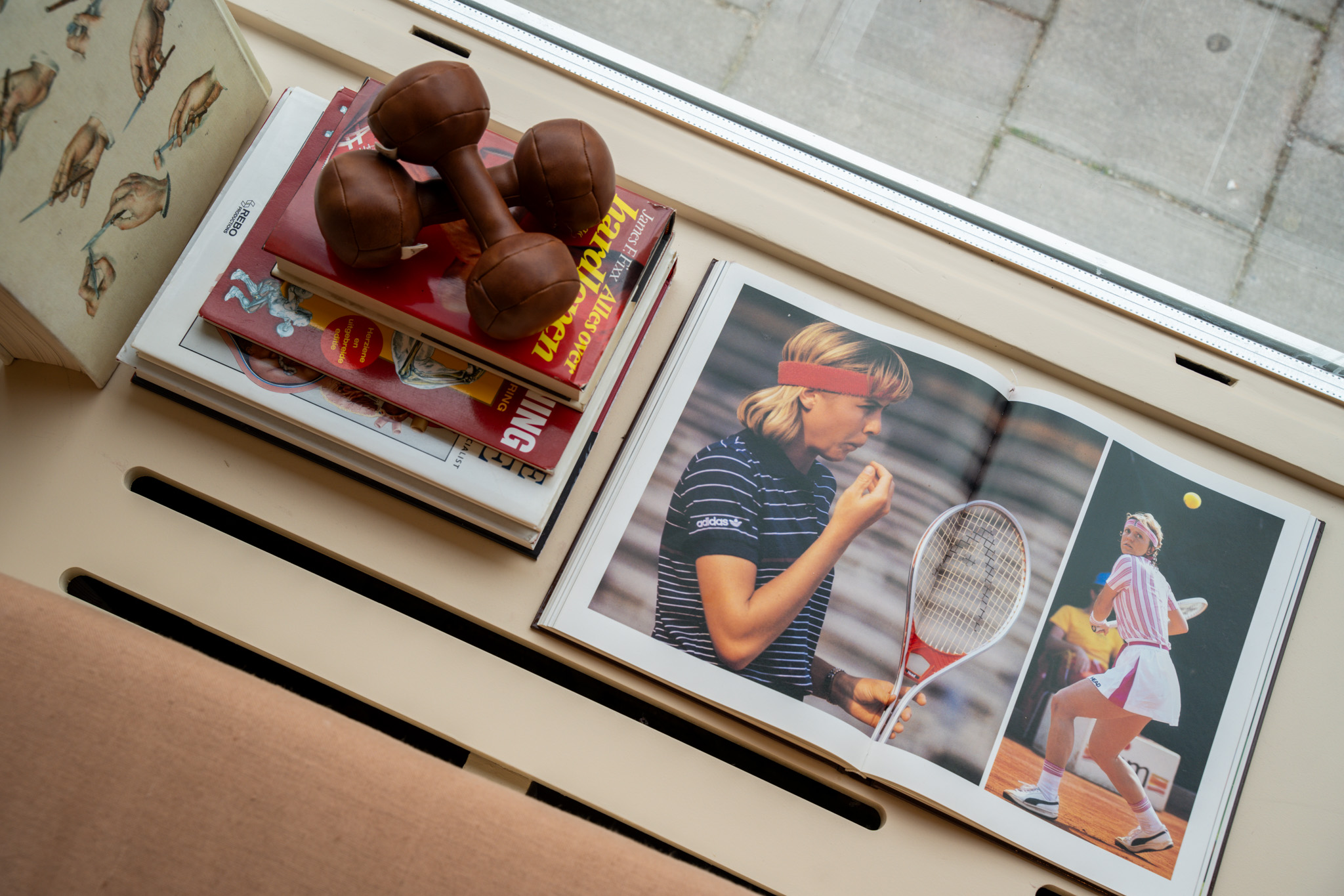 freddies studio bussum close up leren dumbbells op boeken met opengeslagen tennismagazine
