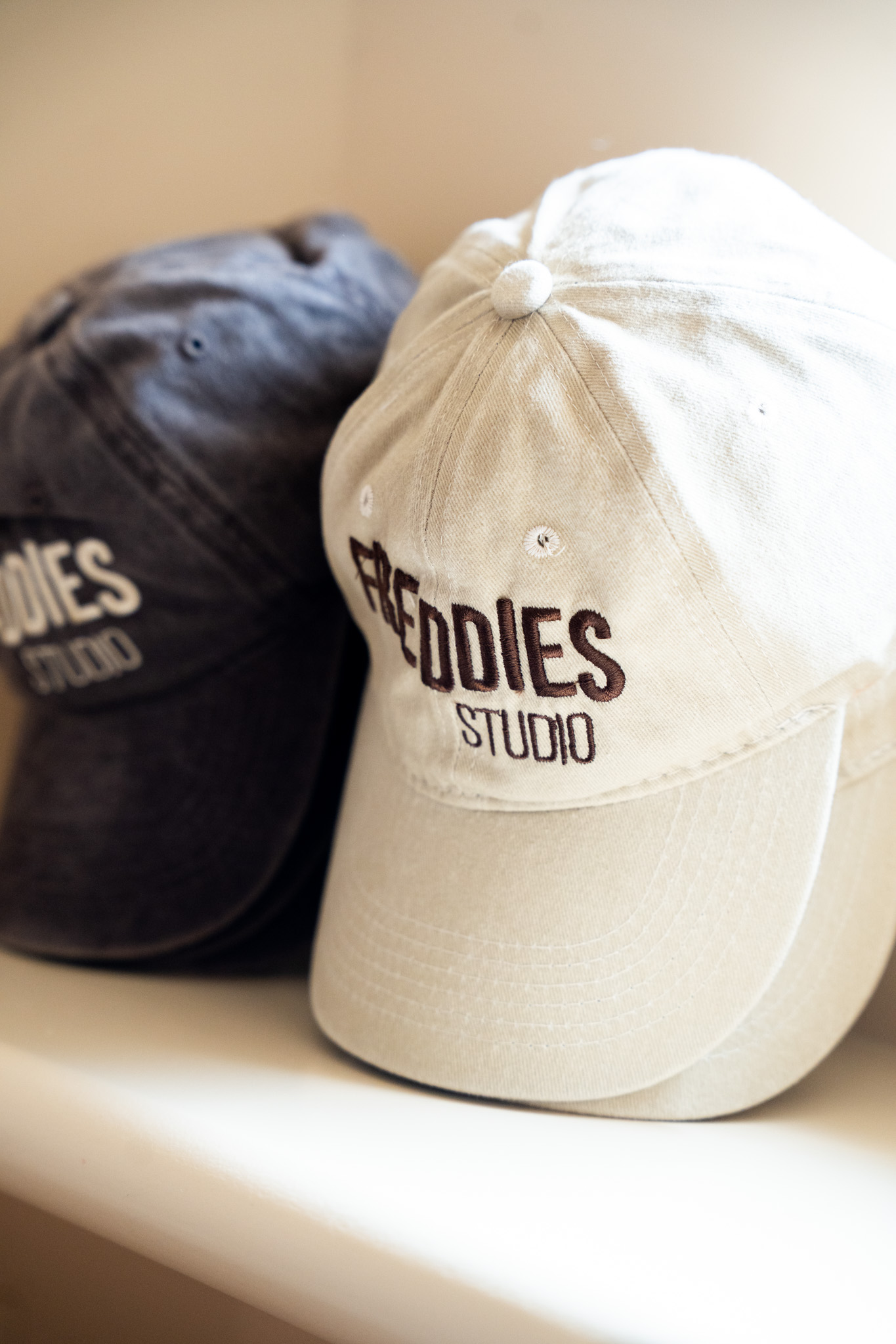 freddies-studio-bussum-close-up-twee-freddies-studio-petten-met-logo-tegen-elkaar