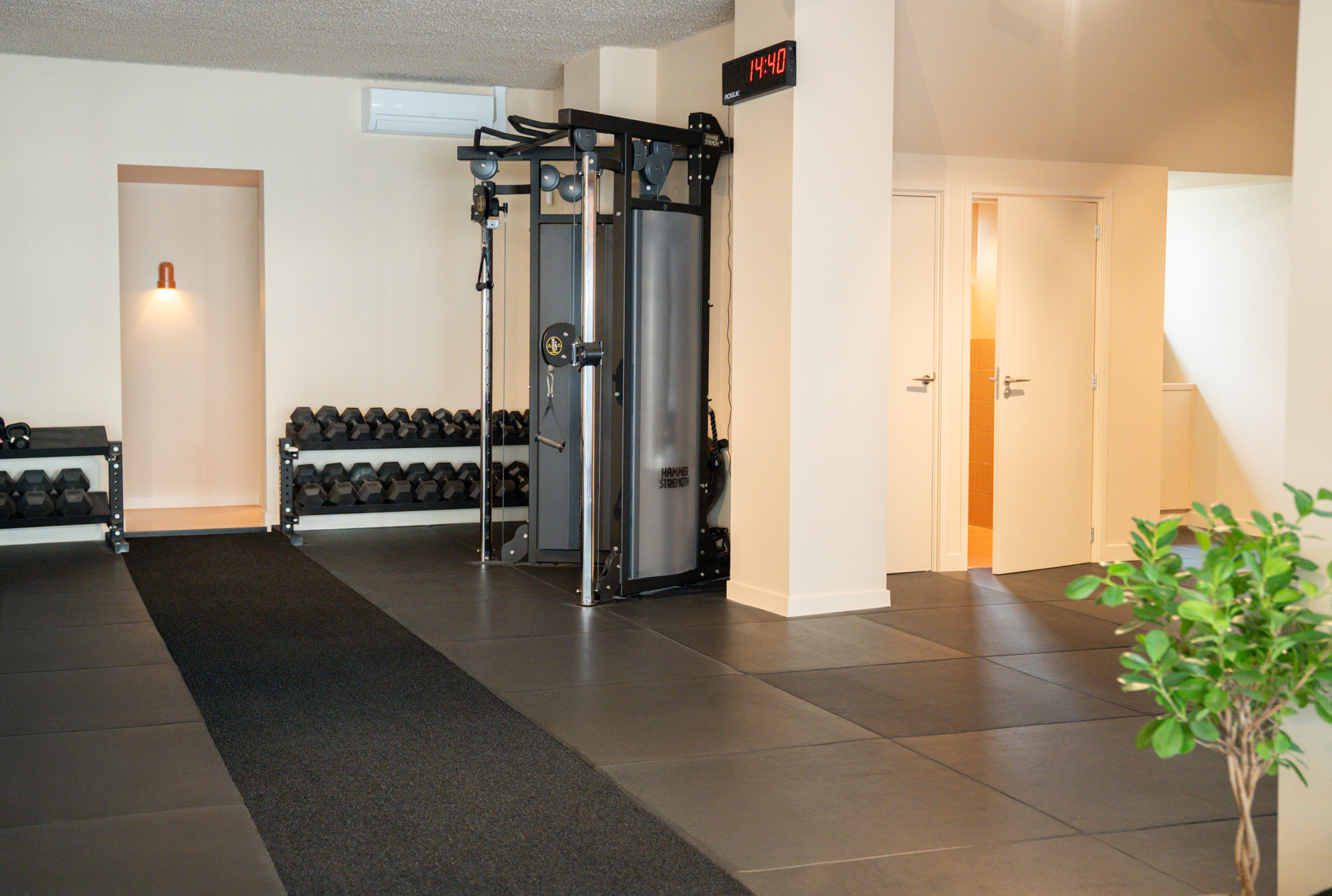 freddies studio bussum doorkijk naar hammer strength machine klok en deuren kleedruimte