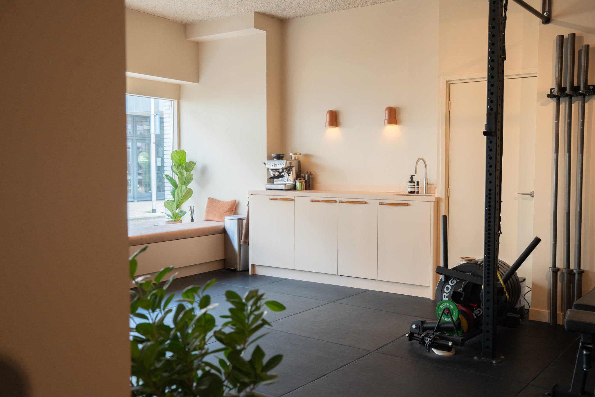 freddies studio bussum doorkijk naar keukenblok en fitnessruimte met sledetrainer