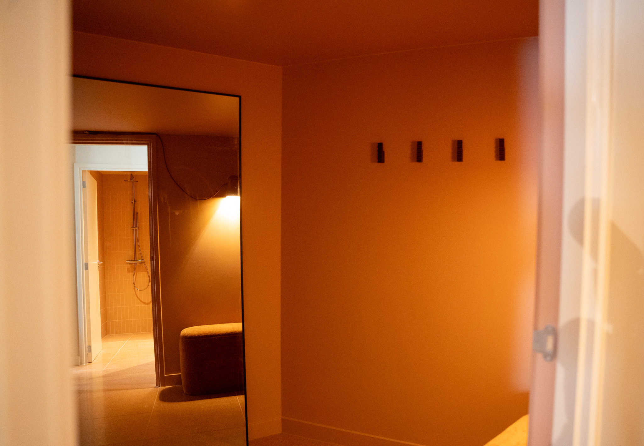 freddies studio bussum doorkijk spiegel naar inloopdouche met terracotta tegels en zitbank