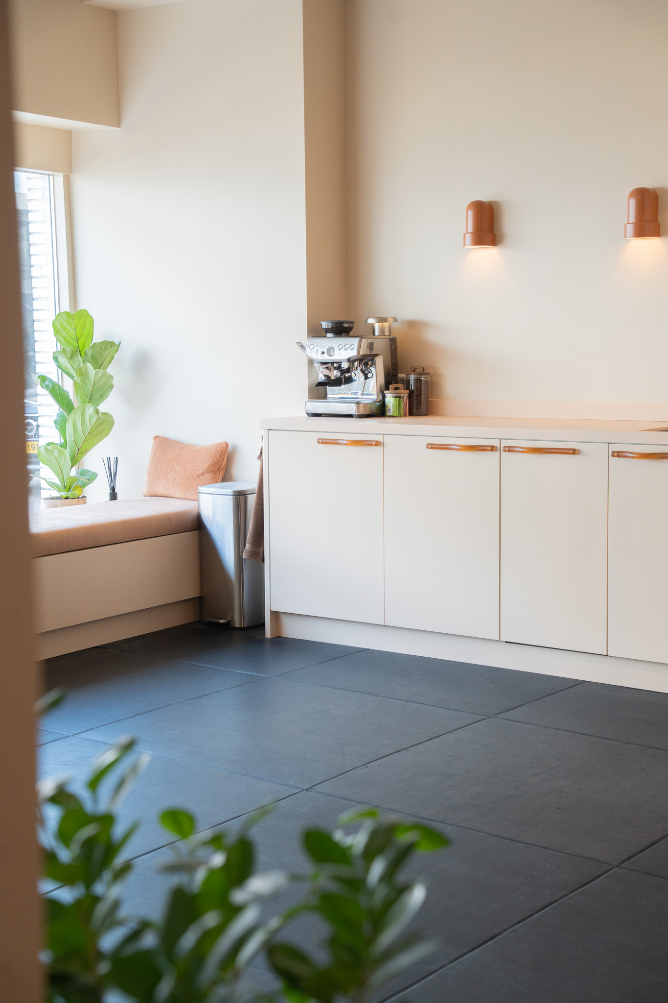 freddies-studio-bussum-doorkijk-vanuit-fitnessruimte-naar-keukenblok-met-vensterbank-en-plant