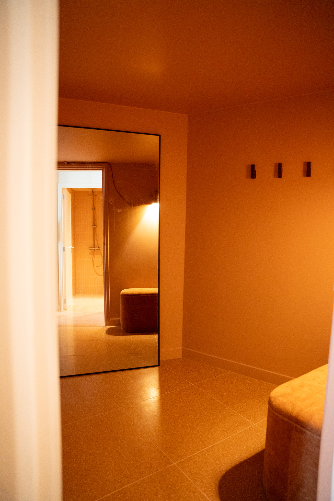 freddies-studio-bussum-doorkijk-vanuit-fitnessruimte-naar-kleedruimte-met-wandlamp