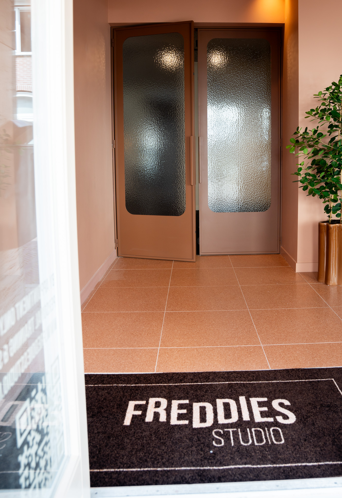 freddies-studio-bussum-entree-met-glazen-deuren-geribbeld-glas-en-deurmat-met-logo