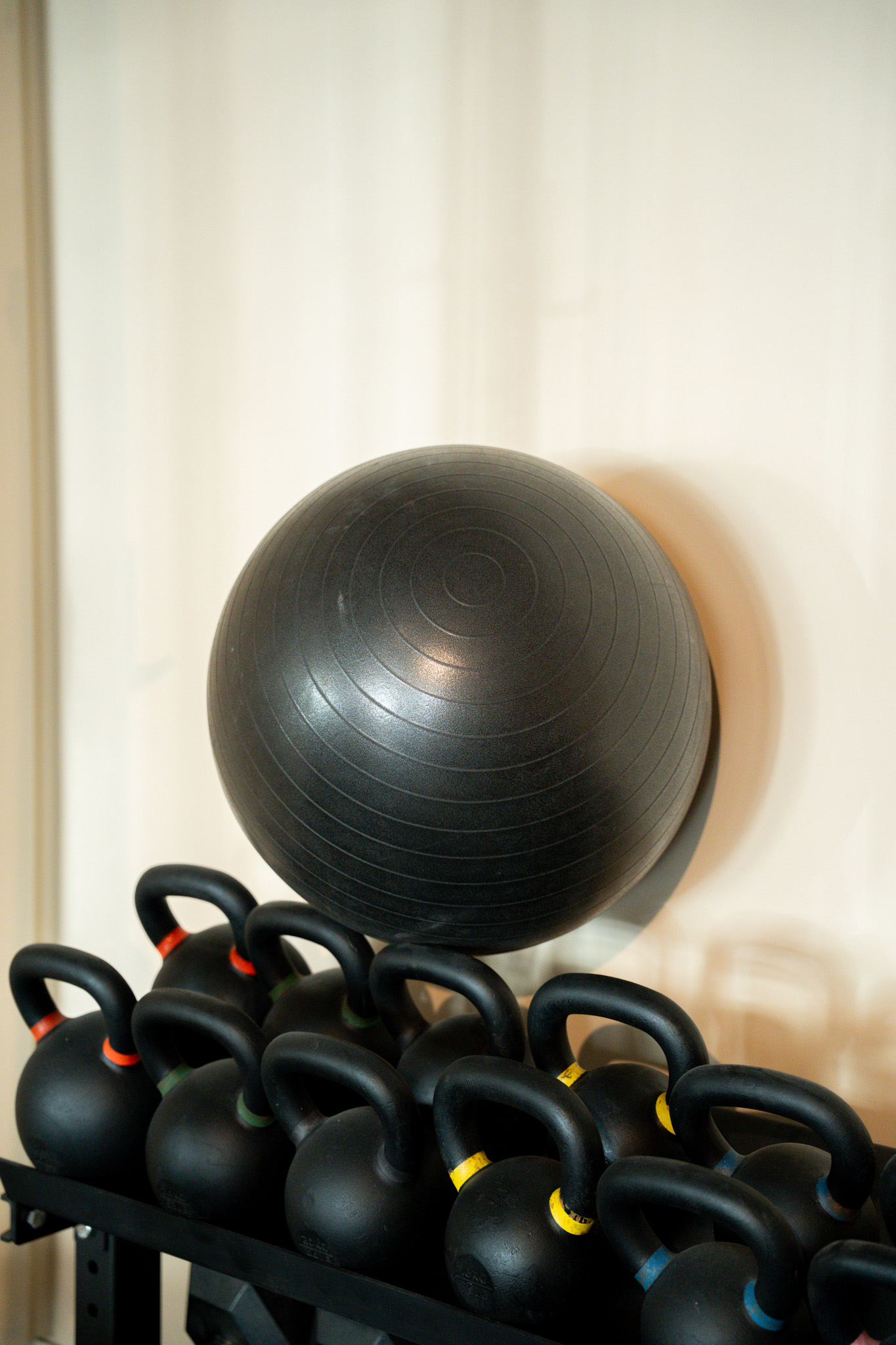 freddies-studio-bussum-fitnessbal-op-kettlebellrek-tegen-witte-muur