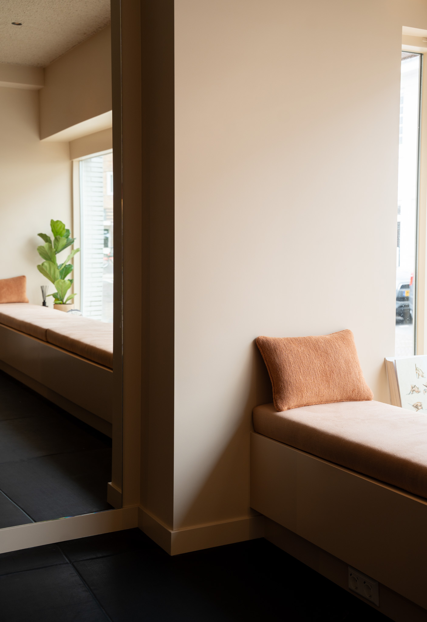 freddies-studio-bussum-gang-met-zitbanken-terracotta-kussens-en-doorkijk-naar-vensterbank-met-plant