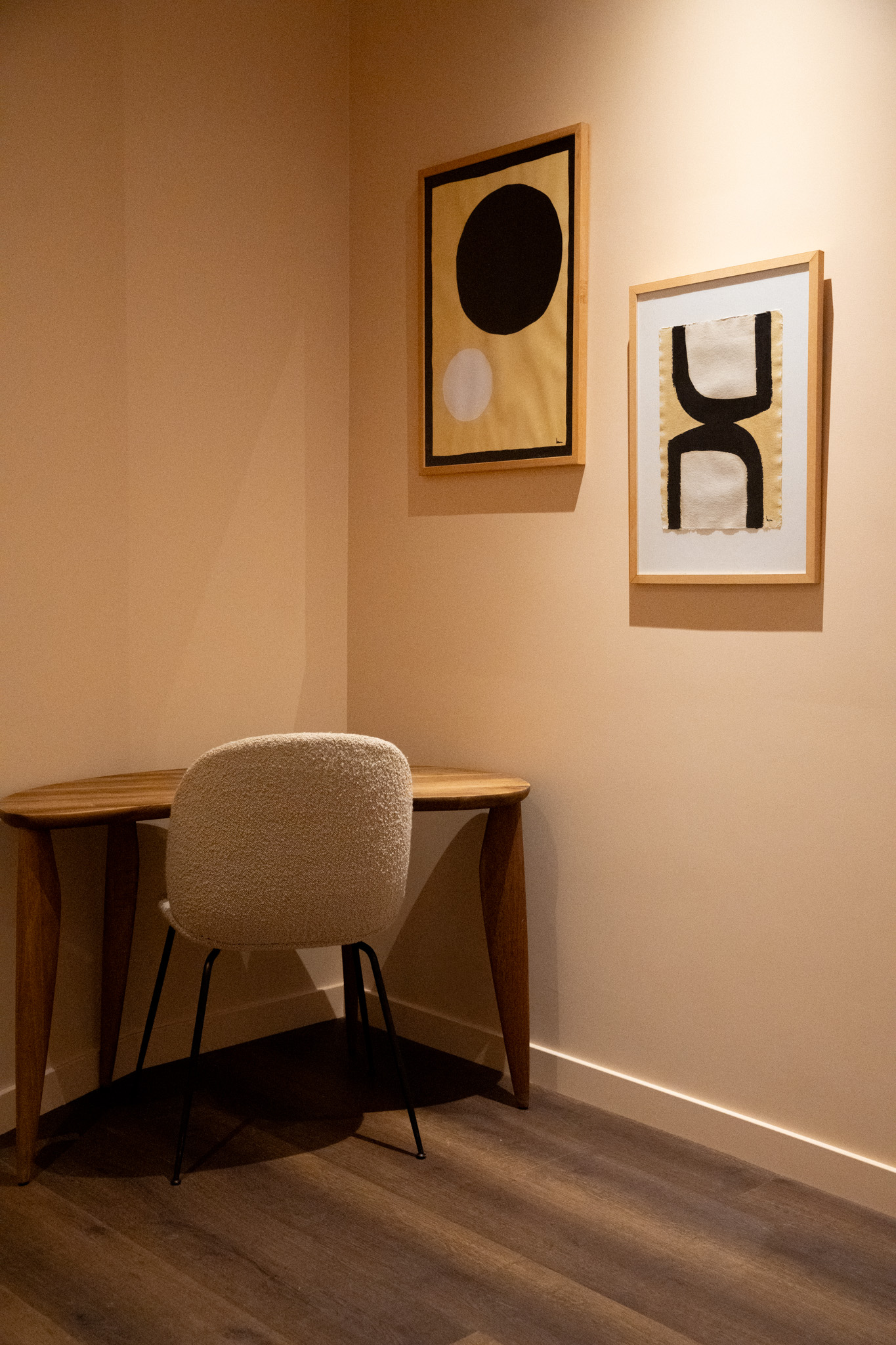 freddies-studio-bussum-houten-bureautafel-met-boucle-stoel-en-abstracte-kunstwerken
