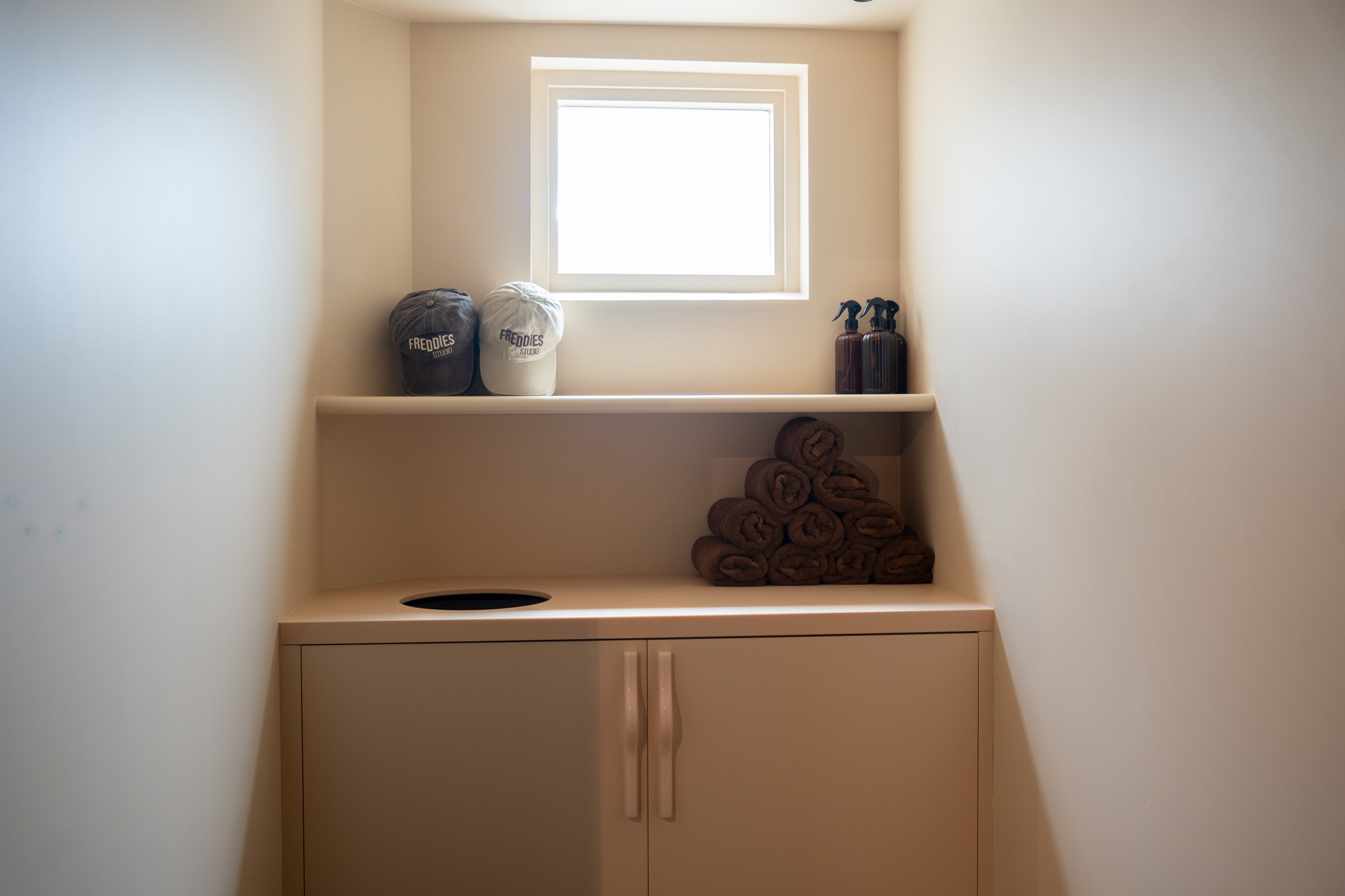 freddies studio bussum kastje met petten sprayflacons en handdoeken bij dakraam andere hoek