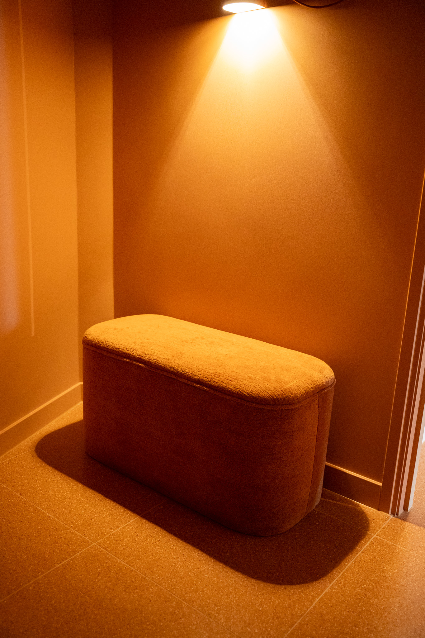 freddies-studio-bussum-kleedruimte-hoek-met-terracotta-bankje-en-wandlamp