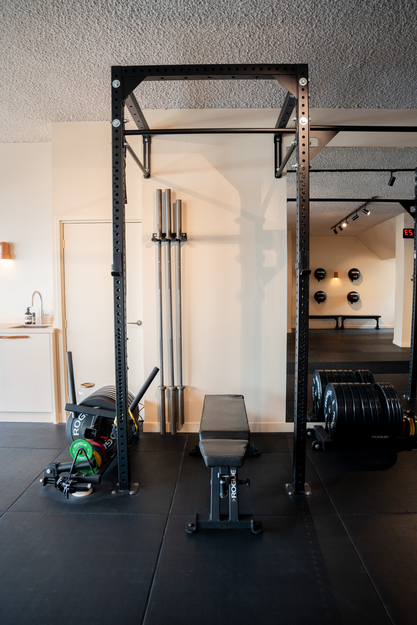 freddies-studio-bussum-power-rack-met-opgehangen-barbells-en-gewichtsschijven-doorkijk-medicijnballen