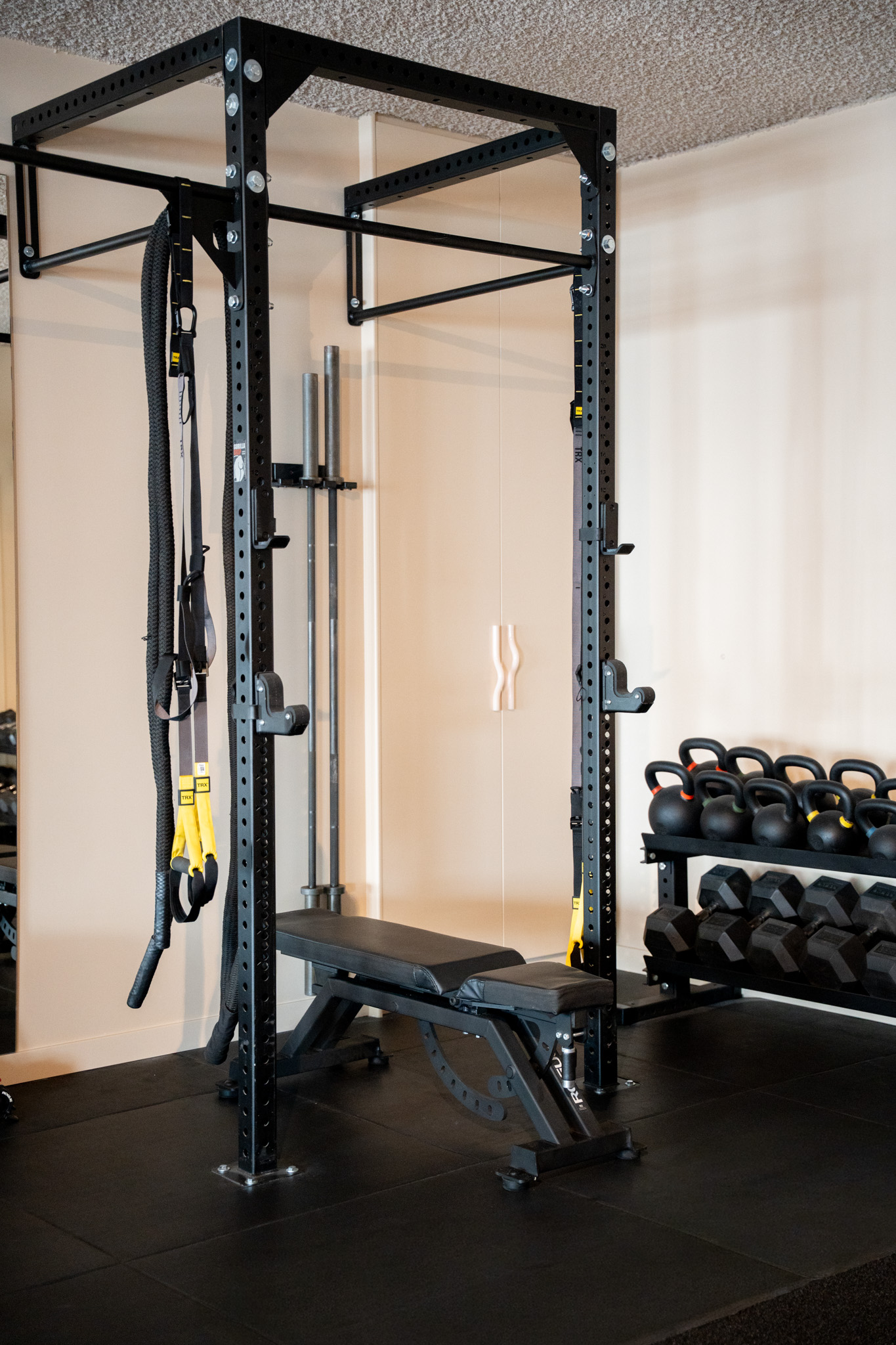 freddies-studio-bussum-power-rack-met-trx-banden-verstelbare-bank-en-kettlebells-op-achtergrond