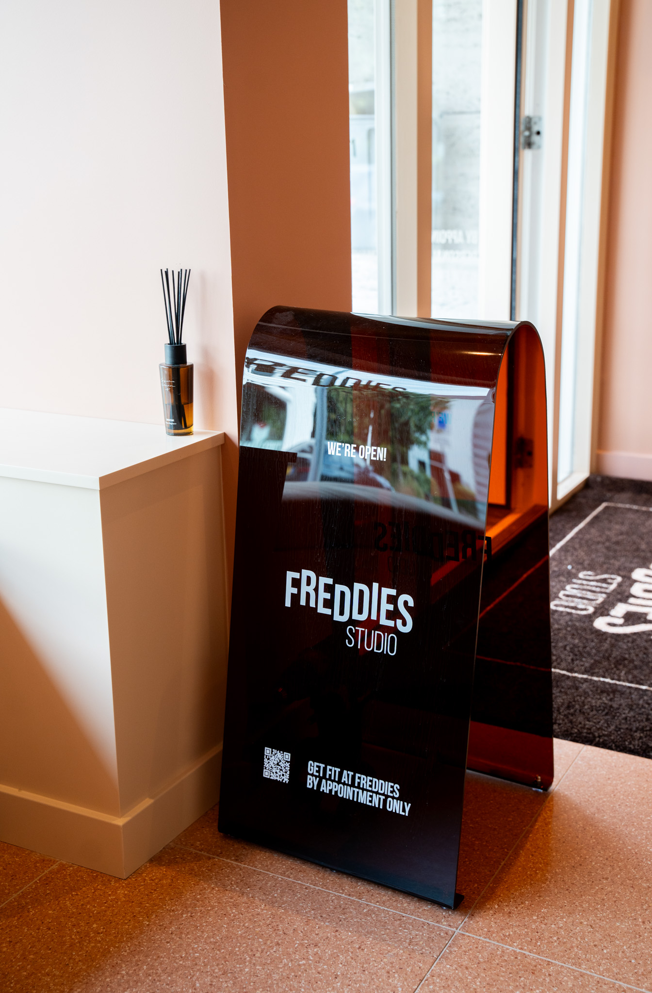 freddies-studio-bussum-reclamebord-bij-ingang-met-geurstokje-en-deur-op-achtergrond