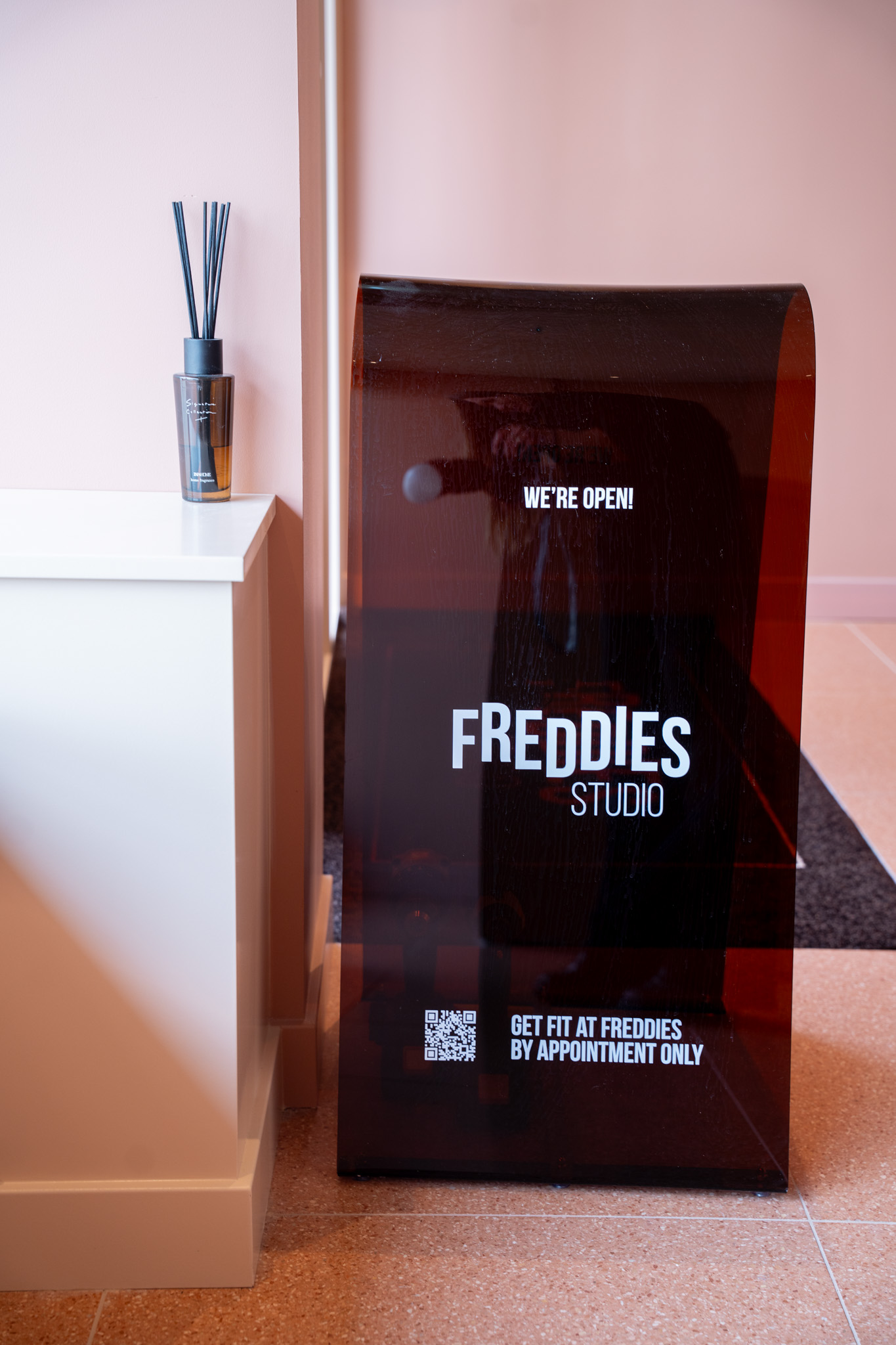 freddies-studio-bussum-reclamebord-met-were-open-tekst-naast-geurstokje-op-kastje