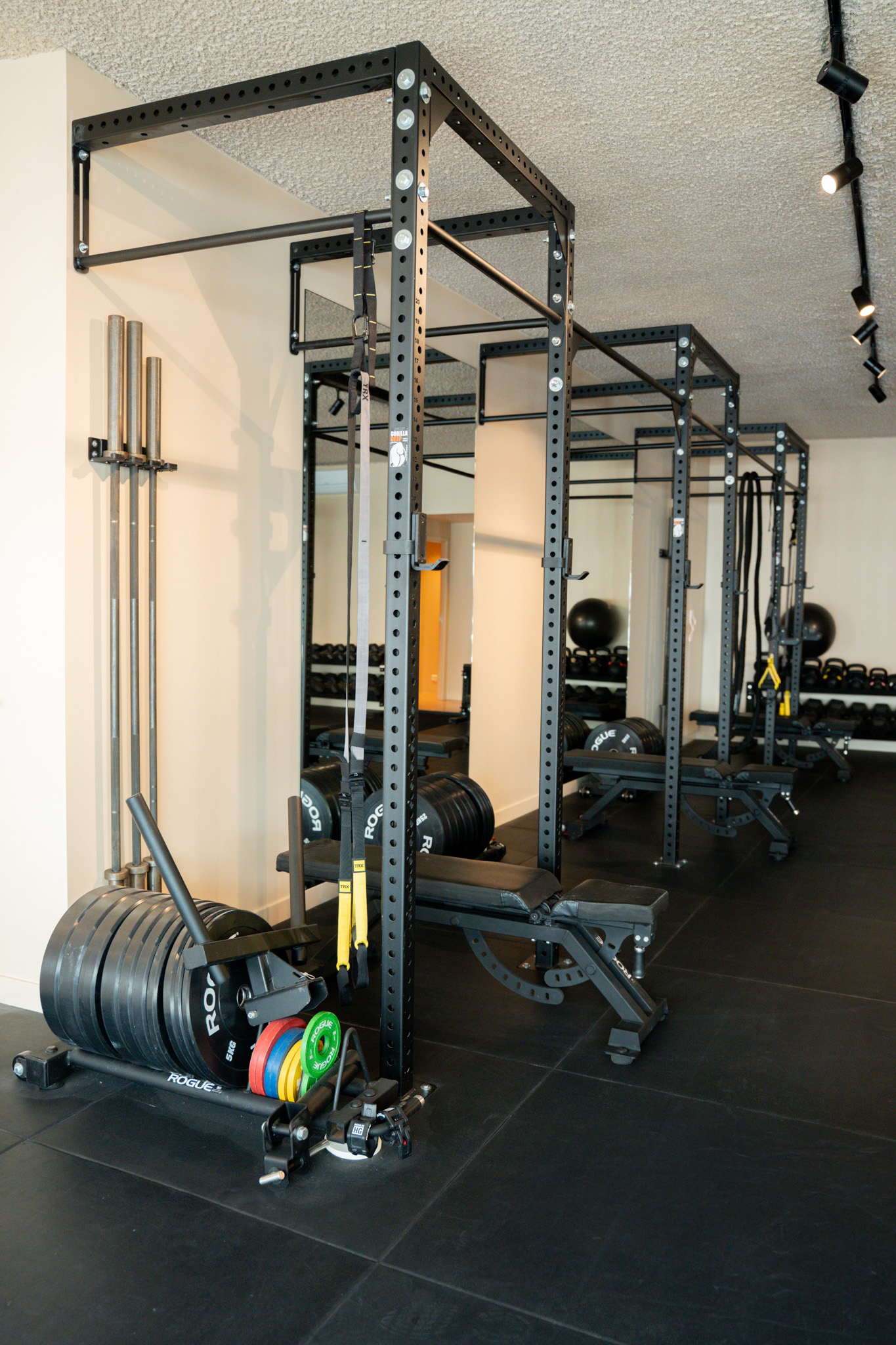 freddies-studio-bussum-rij-power-racks-met-barbell-opslag-rogue-gewichtsschijven-en-trx-banden