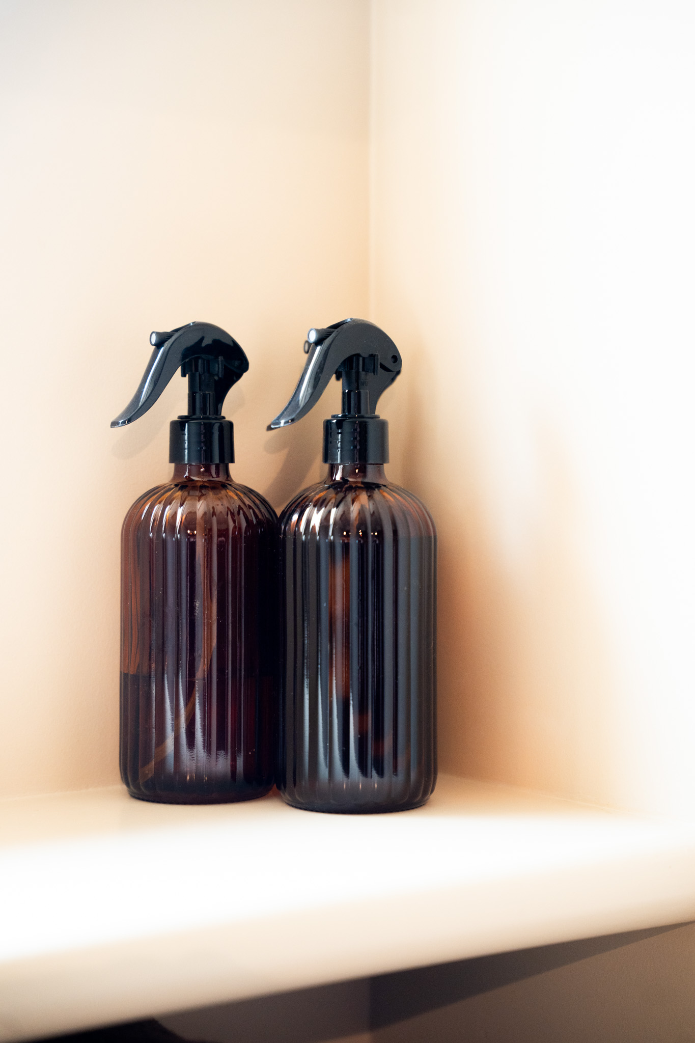 freddies-studio-bussum-twee-bruine-sprayflacons-met-zwarte-trigger-op-plank-in-hoek