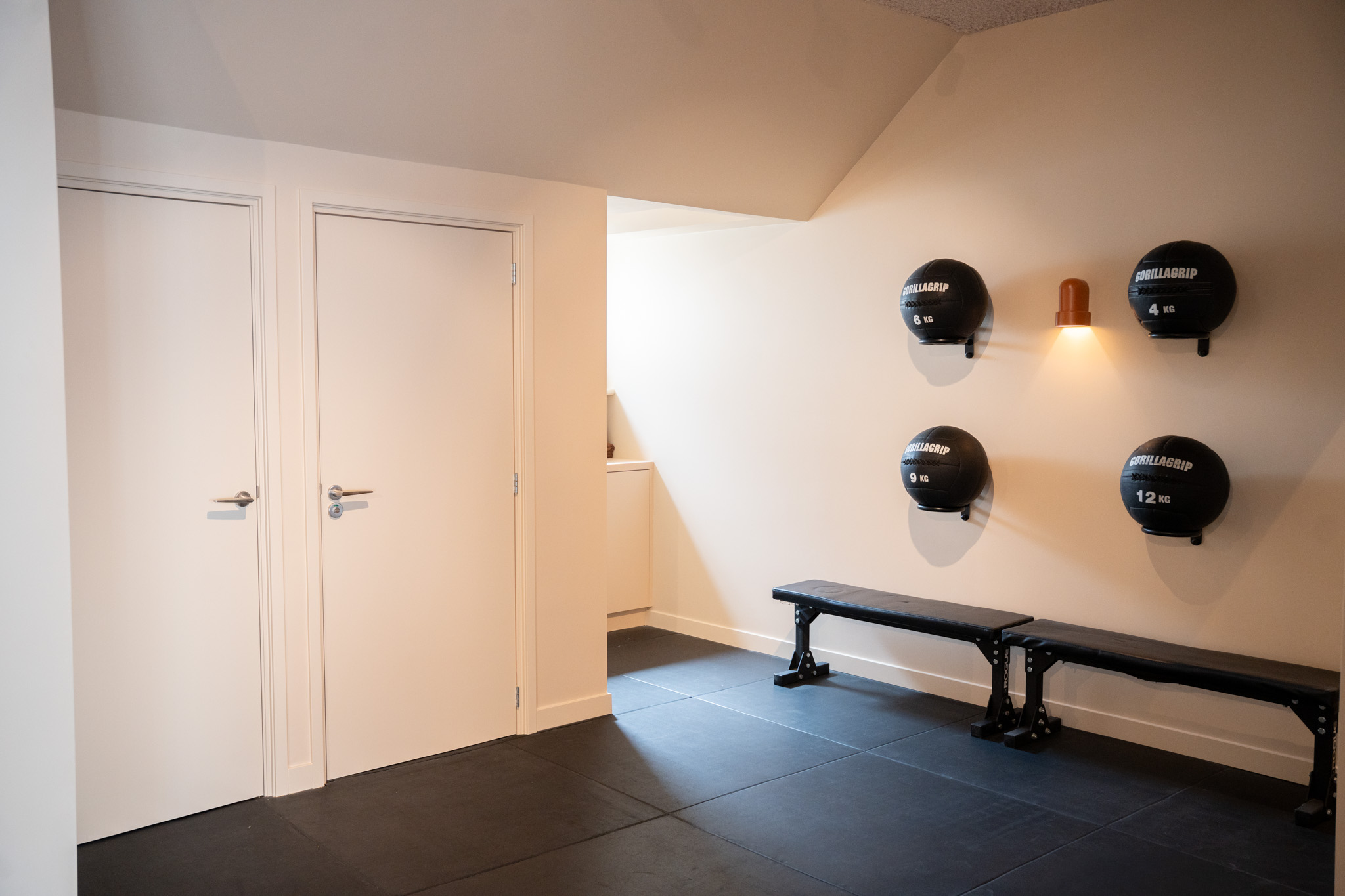 freddies studio bussum twee witte deuren naast gorillagrip medicijnballen en fitnessbanken