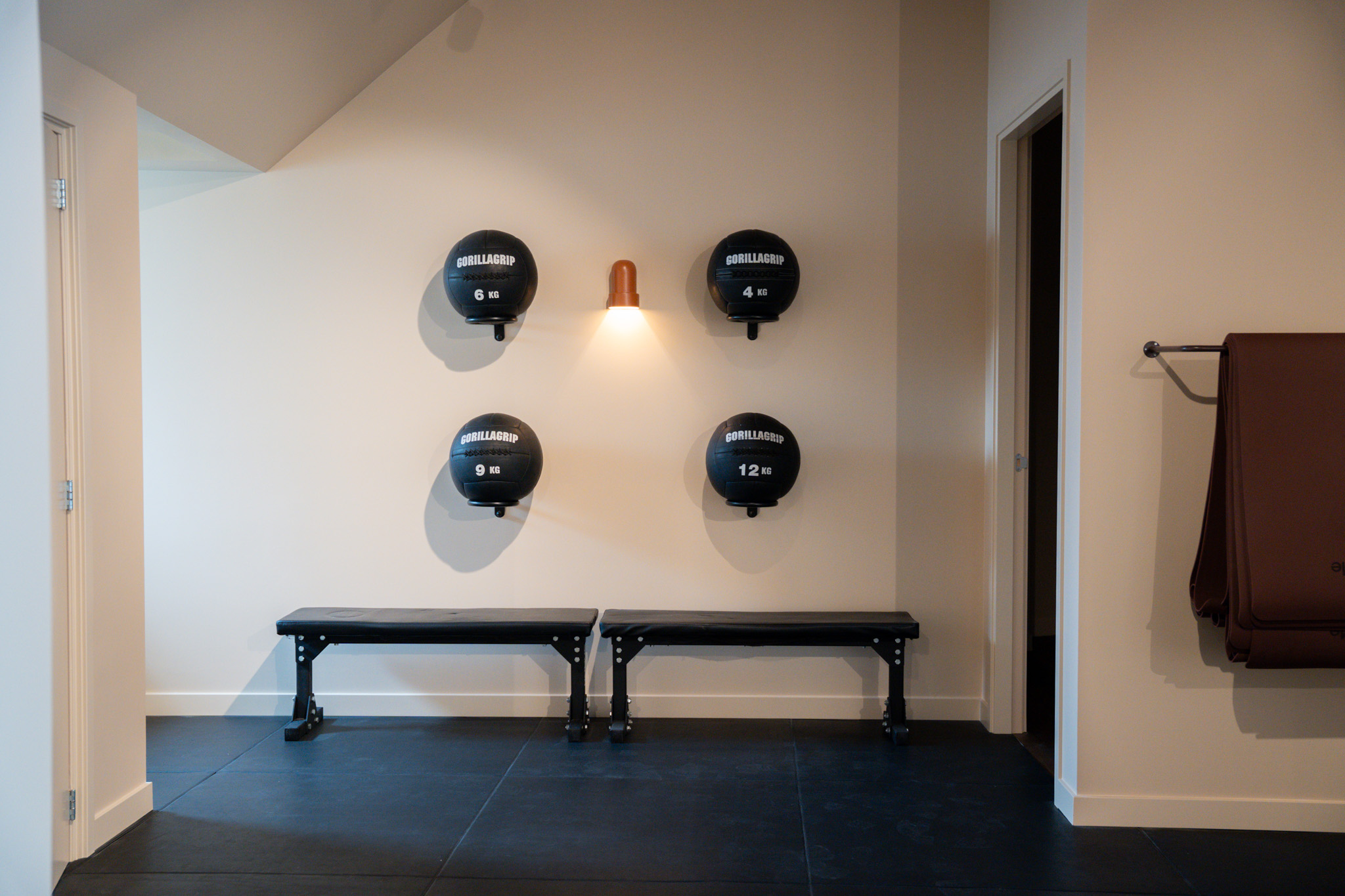 freddies studio bussum vier gorillagrip medicijnballen boven fitnessbanken met wandlamp