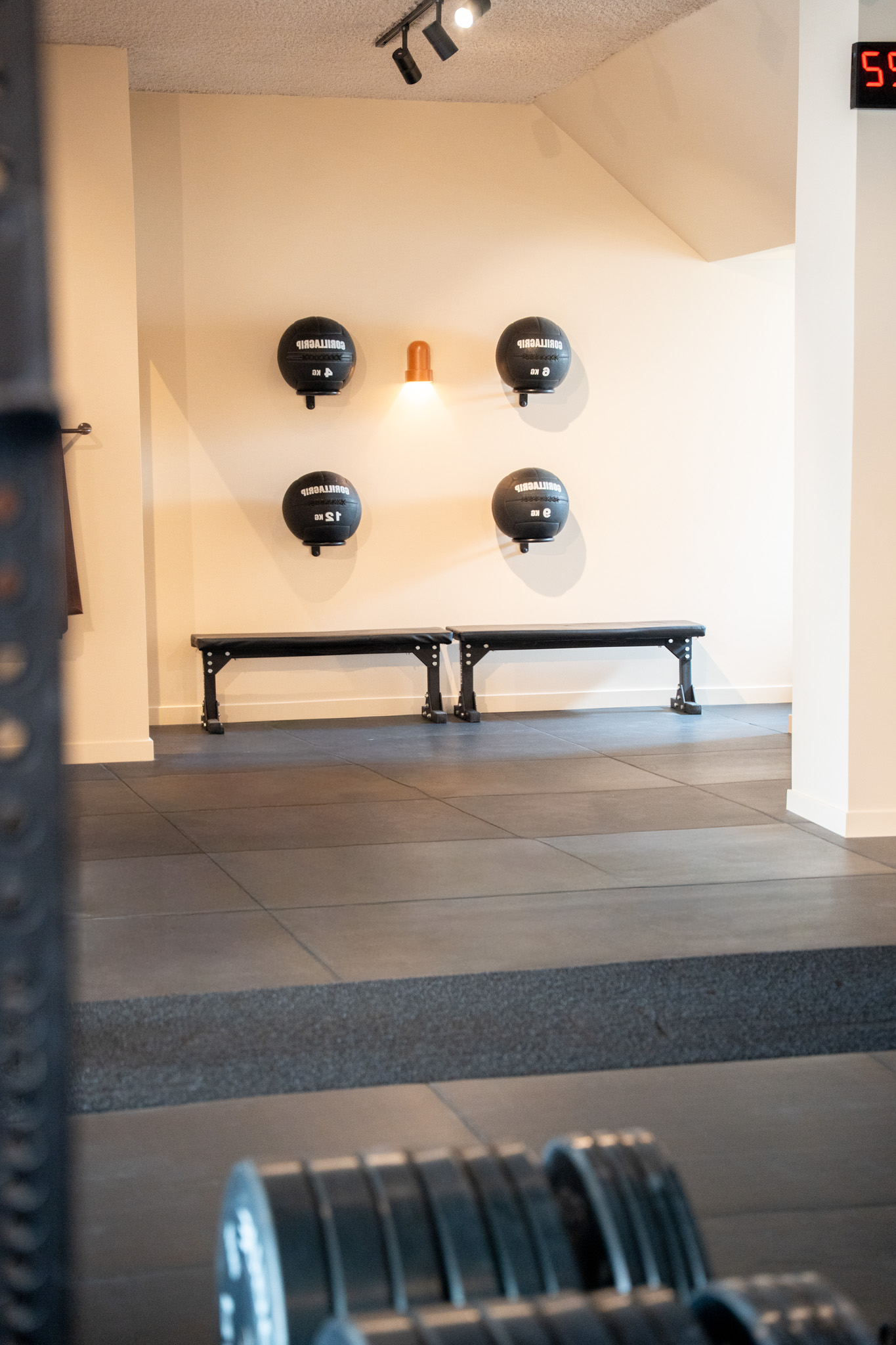 freddies-studio-bussum-vier-gorillagrip-medicijnballen-boven-twee-zwarte-fitnessbanken