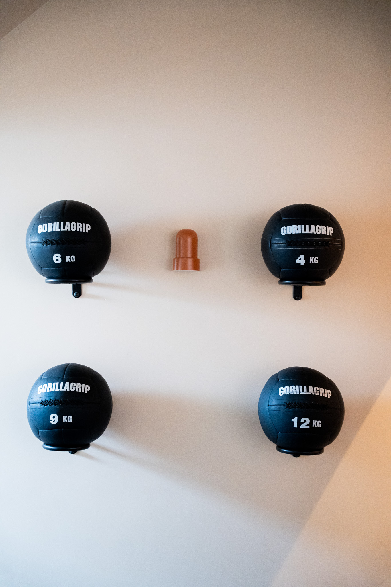 freddies-studio-bussum-vier-gorillagrip-medicijnballen-symmetrisch-aan-muur-met-wandlamp