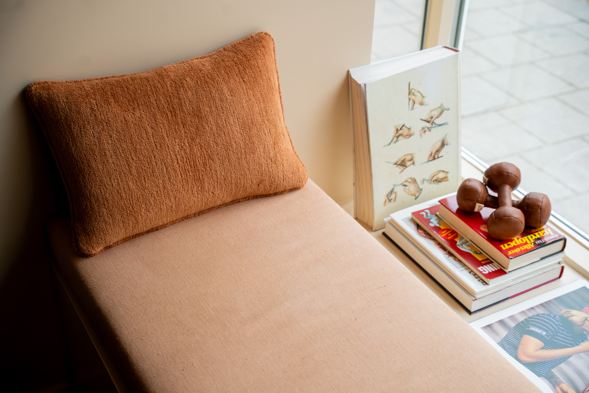 freddies studio bussum zitbank bij raam met terracotta kussen boeken en dumbbells